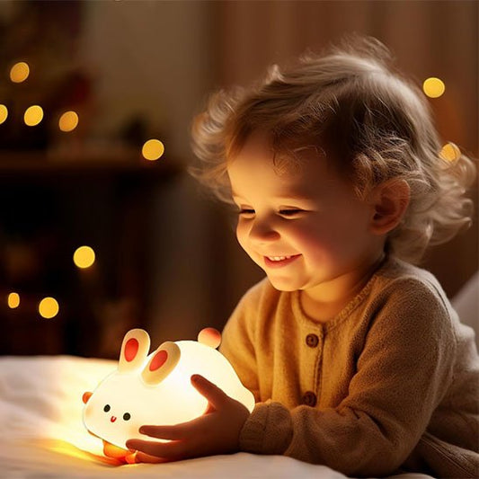 enfant tient en riant veilleuse bebe lapin blanc