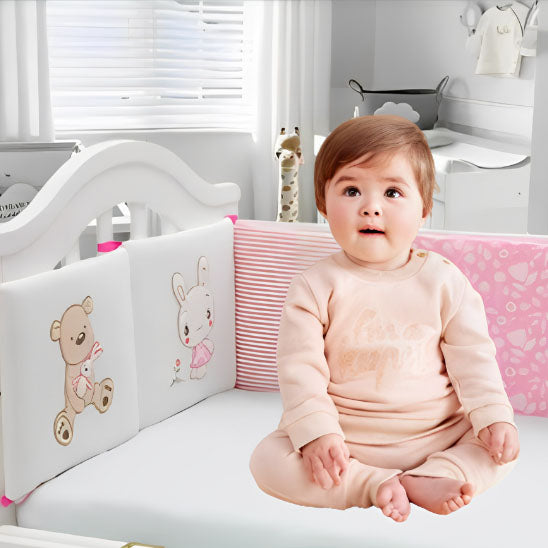 bebe fille assise tour de lit rose blanc