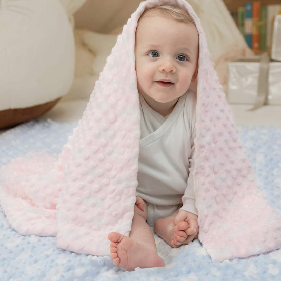 enfant assis couverture bebe rose sur tete
