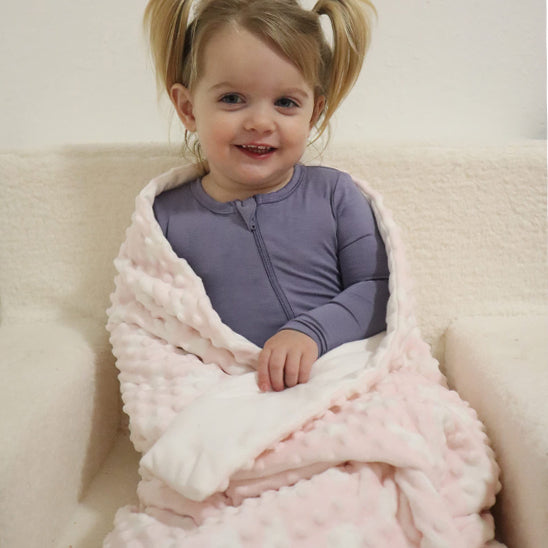fillette assise couverture bebe rose